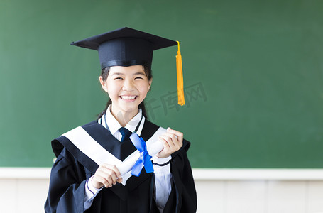 毕业黑板摄影照片_在她的课堂的微笑年轻毕业学生。