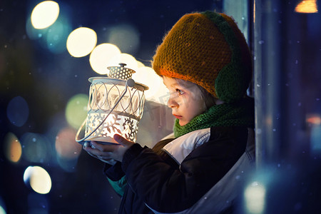 冬季户外男孩摄影照片_可爱的男孩，拿着灯笼户外
