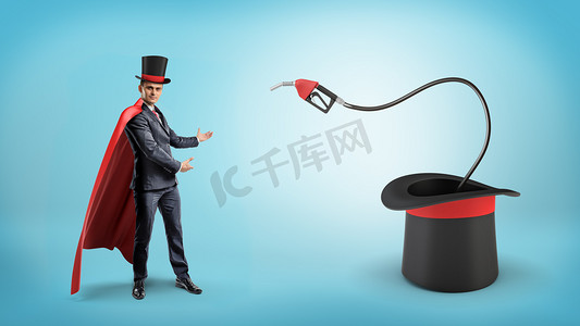欧美斗篷摄影照片_穿着红色的斗篷和大魔术师的帽子商人显示燃料喷嘴内部大魔术师的帽子.