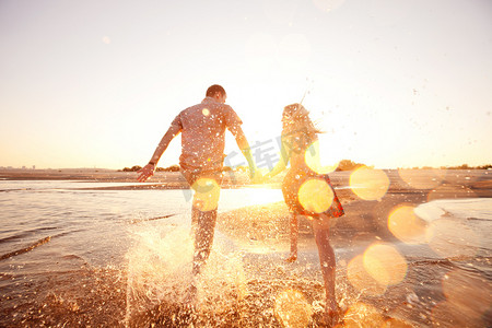 天空海滩摄影照片_夏天在海滩上奔跑的情侣
