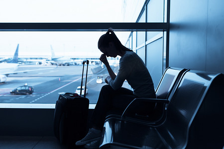 压力的女人在机场拿着智能手机. 