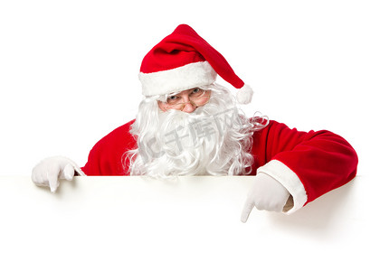 圣诞老人帽子摄影照片_圣诞老人指向空白横幅上