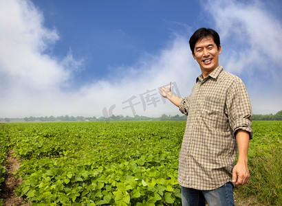 Happy asian farmer showing his farm