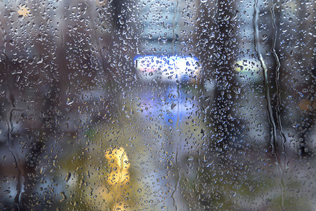 广告窗口摄影照片_晚上的城市灯光的玻璃窗上的雨点