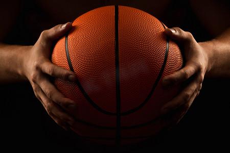 篮球招生摄影照片_在男性手中的篮球球