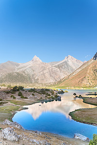 park摄影照片_塔吉克斯坦Fann山区Kulikalon湖上的Pamir山脉景观与和平营地。在纯净的冰湖中追求五彩斑斓的倒影.