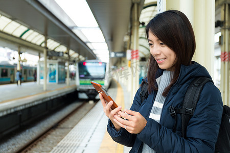 阅读坚持摄影照片_火车站在使用移动电话的女人