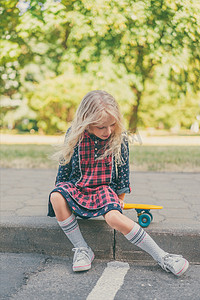 小孩子坐在滑板在城市街道