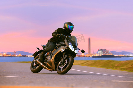 年轻男子骑马运动巡回摩托车在沥青高速公路股份公司