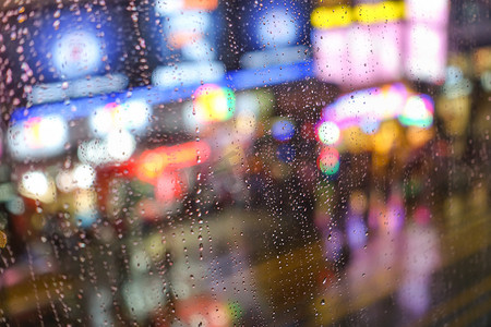 人抽象摄影照片_情感抽象背景与焦的灯景在弥敦道 Hong 本港背后雨滴眼液在窗玻璃-专注于由于浅景深的几滴