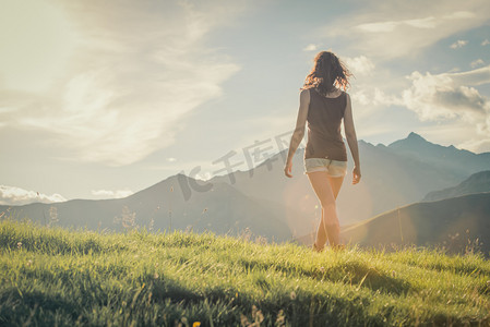 年轻的背后女人山上走在阳光灿烂的日子