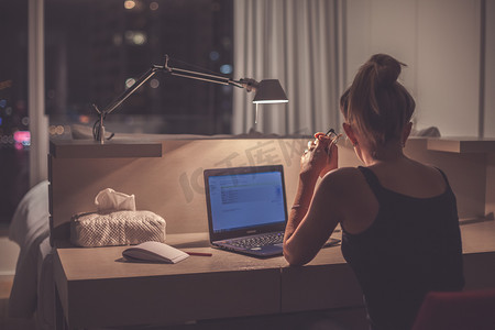 技术工人摄影照片_Young woman overworking in the office