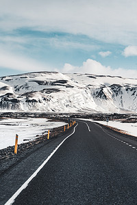 透视蜿蜒的路在冰岛以雪山背景在多云的天秋天季节冰岛.