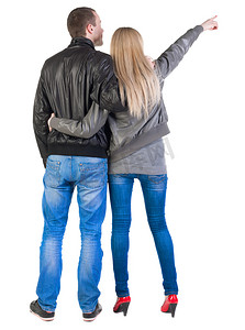 蓝色的牛仔裤摄影照片_指着沃尔玛对年轻的夫妇回视图 （女人和男人).