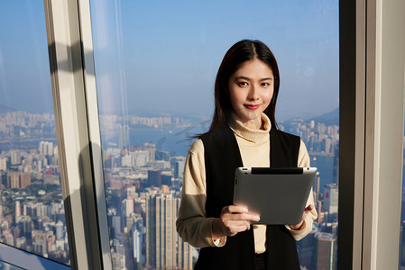 文件2.5摄影照片_Young Asian woman is holding portable digital tablet