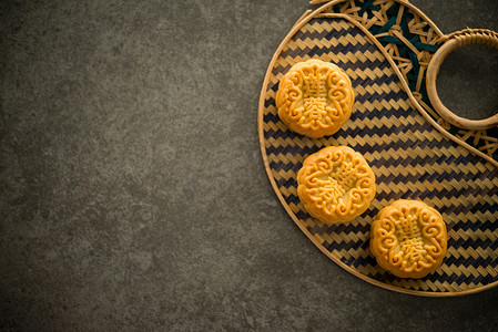 甜月饼摄影照片_中秋节期间, 传统的糕点月饼提供给亲朋好友。Flatlay 表顶部查看带有复制空间的暗光。月饼中的汉字代表英语中的 