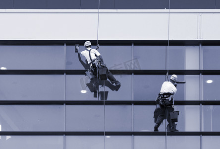 劳动现代摄影照片_两名工人清洗 windows 的现代建筑