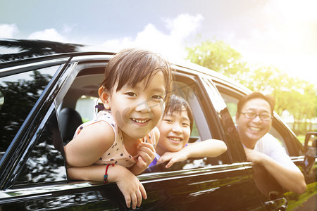 开车男人摄影照片_快乐的小女孩与家人围坐在车里