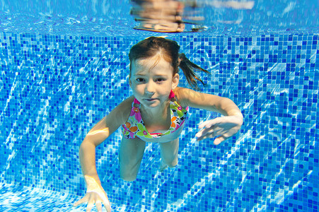 aqua摄影照片_快乐的微笑水下孩子在游泳池
