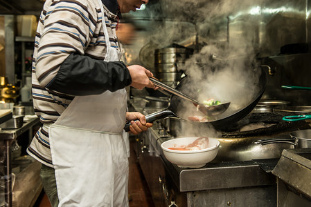 火锅摄影照片_在火炉上用锅餐厅厨房里的厨师