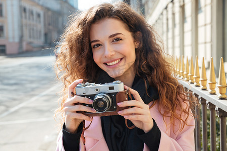年轻女子捧着复古照相机的图片