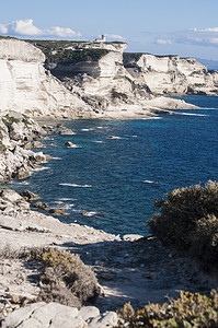 科西嘉: 博尼法西奥的壮观的白色石灰石峭壁在国际 Bouches de 博尼法西奥海岸公园, 自然保护区在1993年建立了, 与海角 Pertusato 灯塔的看法