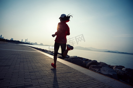 运动体育店摄影照片_运动的年轻健身妇女运行在日出海滨