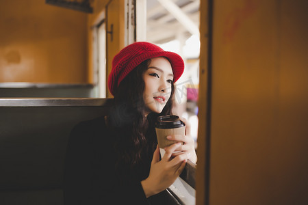 周末好摄影照片_肖像迷人的美丽的旅行女人。迷人的美丽女子是旅游地点或旅游景点的老式火车。华丽的女人看风景和举行一杯咖啡