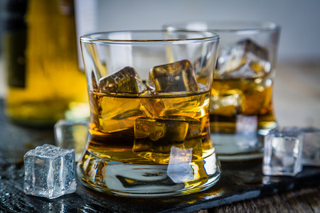 玻璃窗厚度摄影照片_杯子里放冰块的威士忌特写