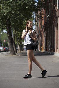 衣服鞋子衣服摄影照片_年轻漂亮的女人，穿着蓝色的衣服，走在夏天压力