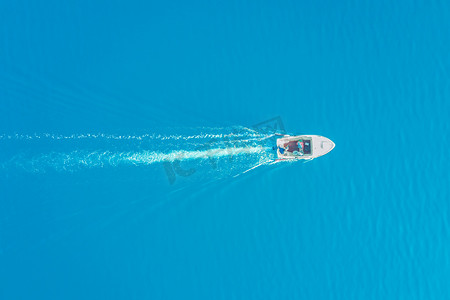 蓝色帆船摄影照片_顶视图的白船在蔚蓝的大海中航行