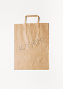 买商品摄影照片_Craft shopping bag isolated on white background. Vertical