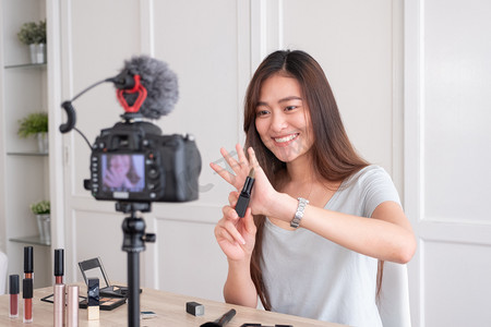 直播表摄影照片_亚洲年轻女性博客录制沃客视频与化妆化妆品在家里在线影响社会媒体的概念. 实时流病毒 