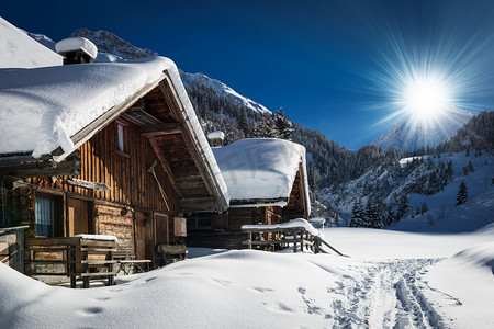 雪景天空摄影照片_冬季滑雪的小木屋和小木屋里山雪景