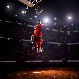 红色活动活动摄影照片_红色的篮球运动衣的运动员扣篮