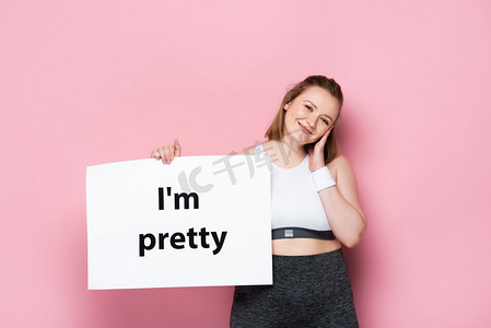 女孩卡片摄影照片_超重的女孩拿着标语牌漂亮的粉红题词 