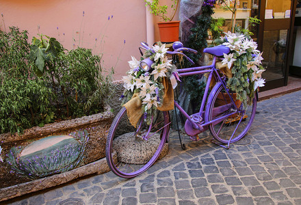 彩色建筑摄影照片_用花来装饰的彩色画的自行车 