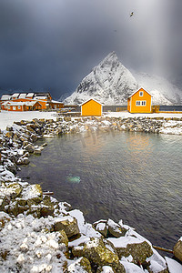 两个传统生动的黄色挪威独立的房子位于挪威的瑞尼村湾。垂直图像组合