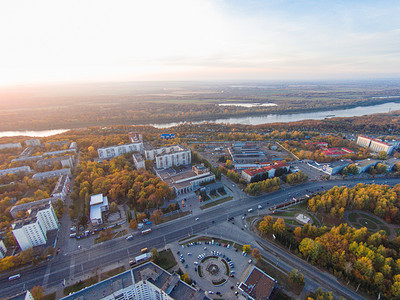 工厂鸟瞰图摄影照片_在城市的秋天。在道路、 森林、 河全景鸟瞰图.