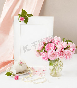 周年庆艺术字摄影照片_静物与束玫瑰花茶、 丝绸、 perl 项链和艺术背景上的杯子