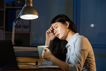 晚摄影照片_亚洲业务女人喝咖啡提神加班拉