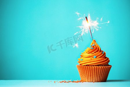 生日蛋糕背景横向摄影照片_与烟火橙色蛋糕