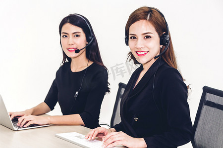 美丽的女实业家客户支持服务在呼叫中心使用耳机和计算机