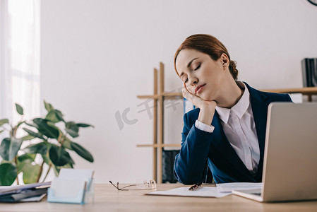 疲倦的女商人在工作场所睡觉