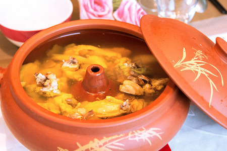 汽水肉摄影照片_来自中国云南省的食品特色菜：气锅鸡或蒸锅鸡。鸡被蒸入锅中，锅中有一个洞，从锅外的蒸汽中获取蒸汽水，以获得一种紧张的味道.