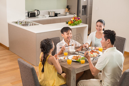 亚洲家庭亲子摄影照片_亲子一家人在厨房吃饭