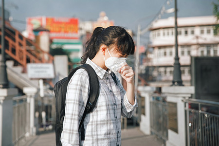 保护妇女摄影照片_亚洲妇女戴口罩咳嗽，因为空气污染 