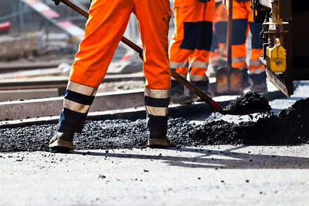 公路铁路摄影照片_道路施工，工人用铲子