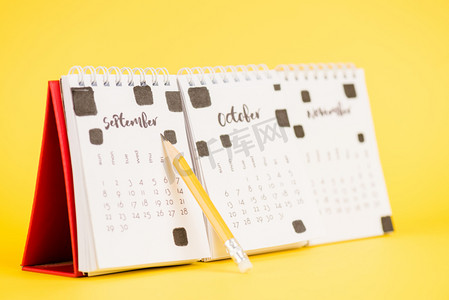 选择1摄影照片_靠近日历的铅笔，底色为黄色，九月为九月