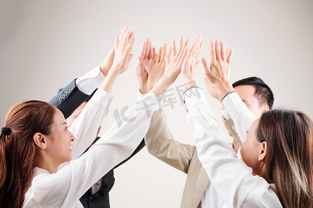 公司活动摄影照片_商务团队一群亚洲商界人士举起双臂互相庆祝自己的成功